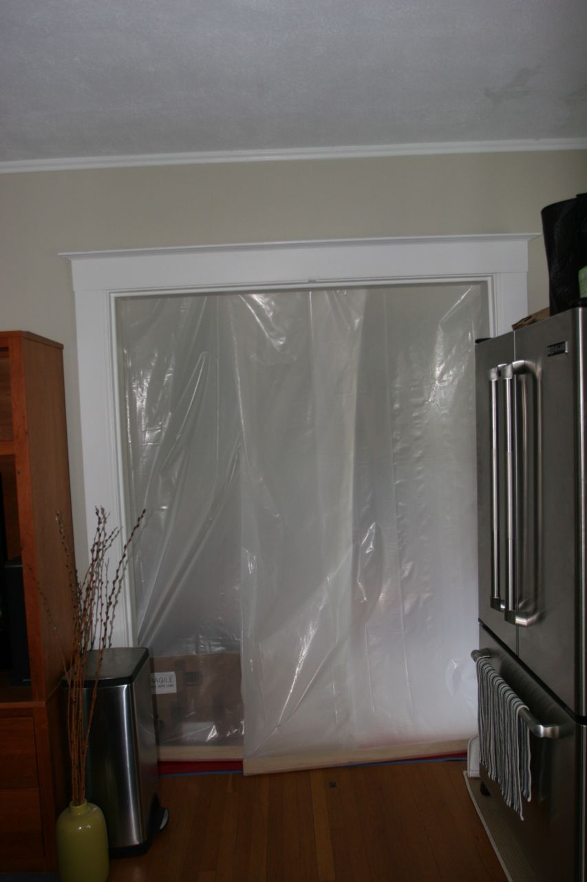 I realized I hadn't posted anything of our current "kitchen." Through that plastic door is the foyer.