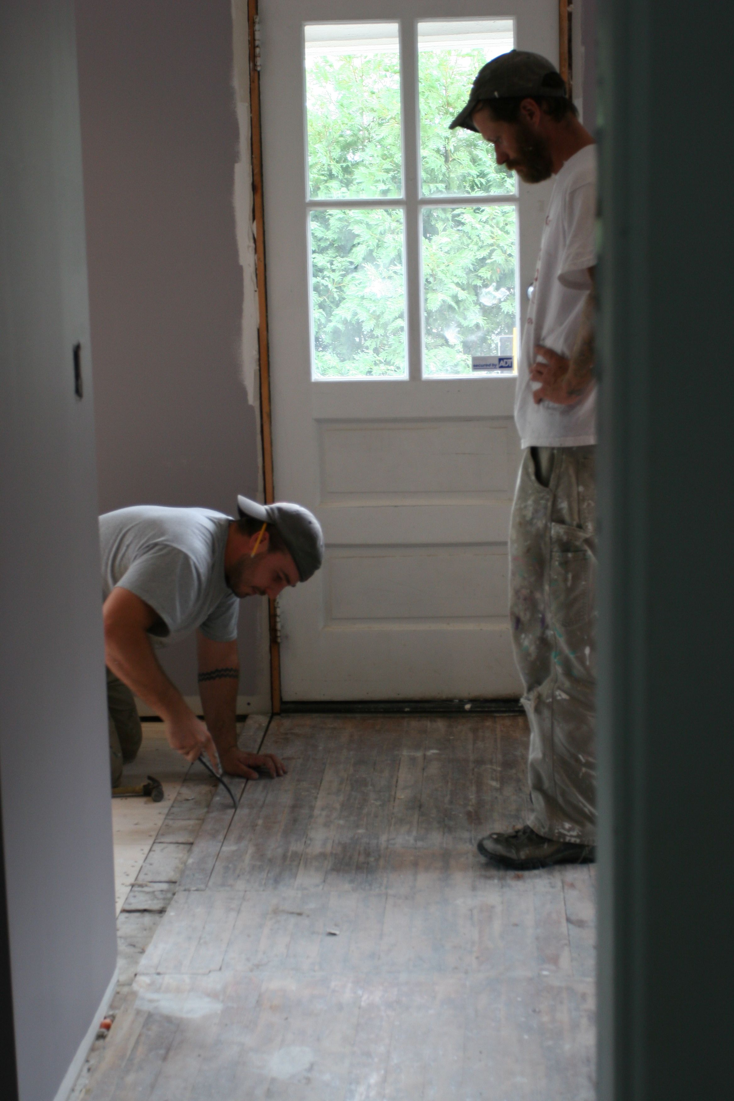 Dave gently removing the antique boards while Eric watches.