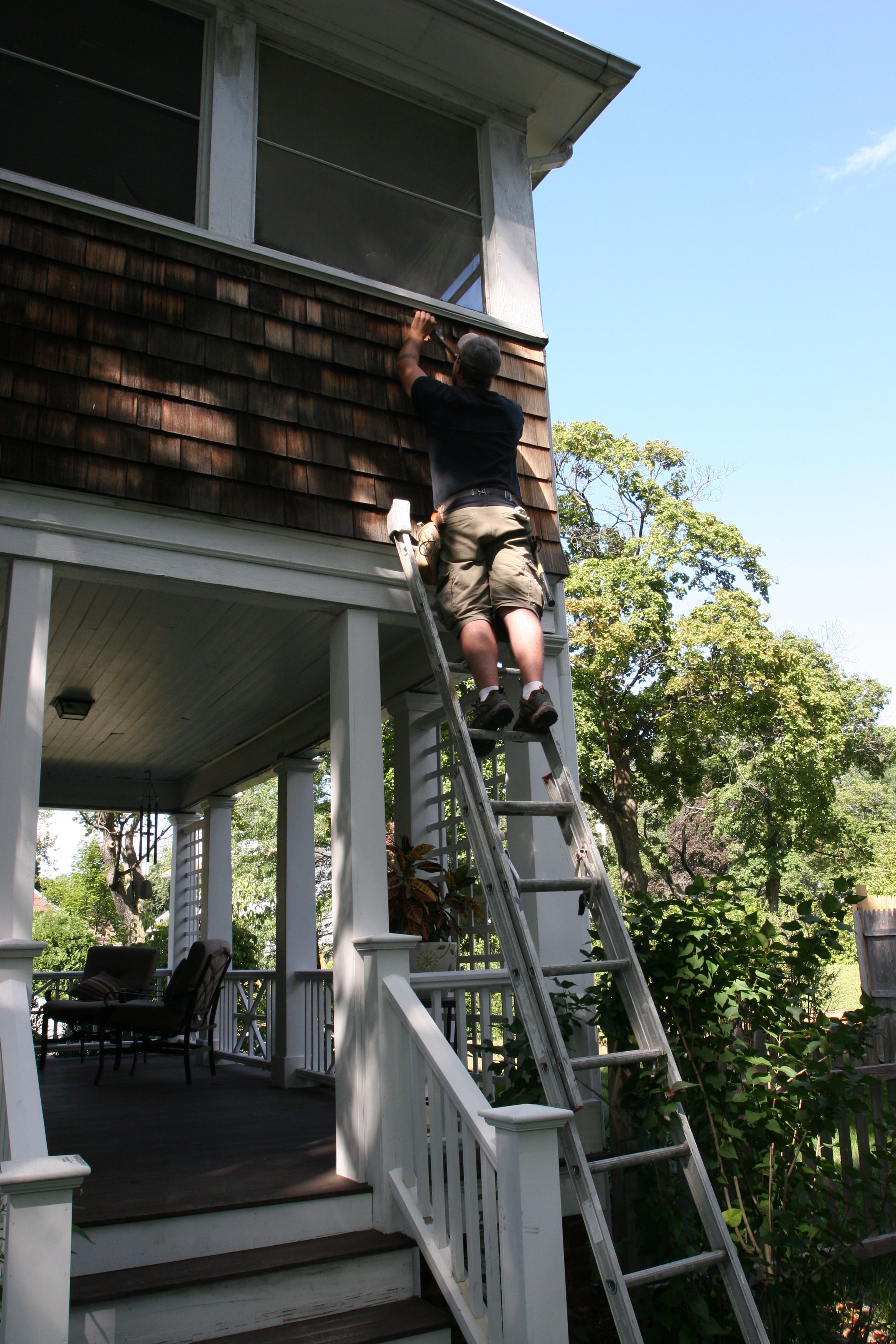 Dave removing aged shingles to replace on the driveway side of the house.