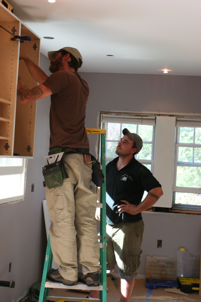 Attaching the second cabinet to the wall.