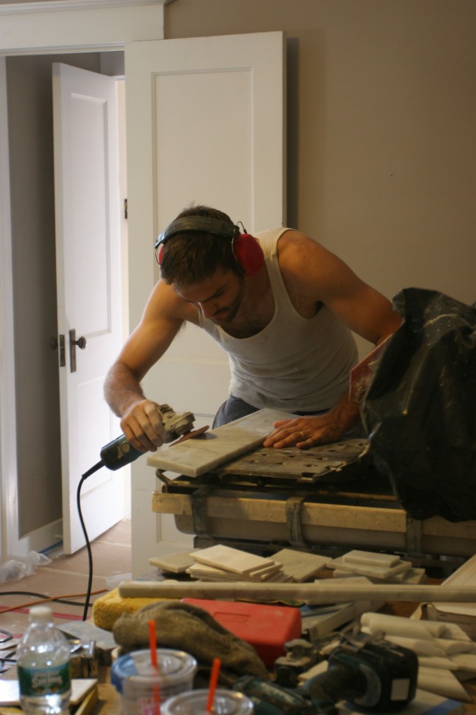 Caleb hand shaping a threshold that he cut from the larger, wider marble door jamb pieces.