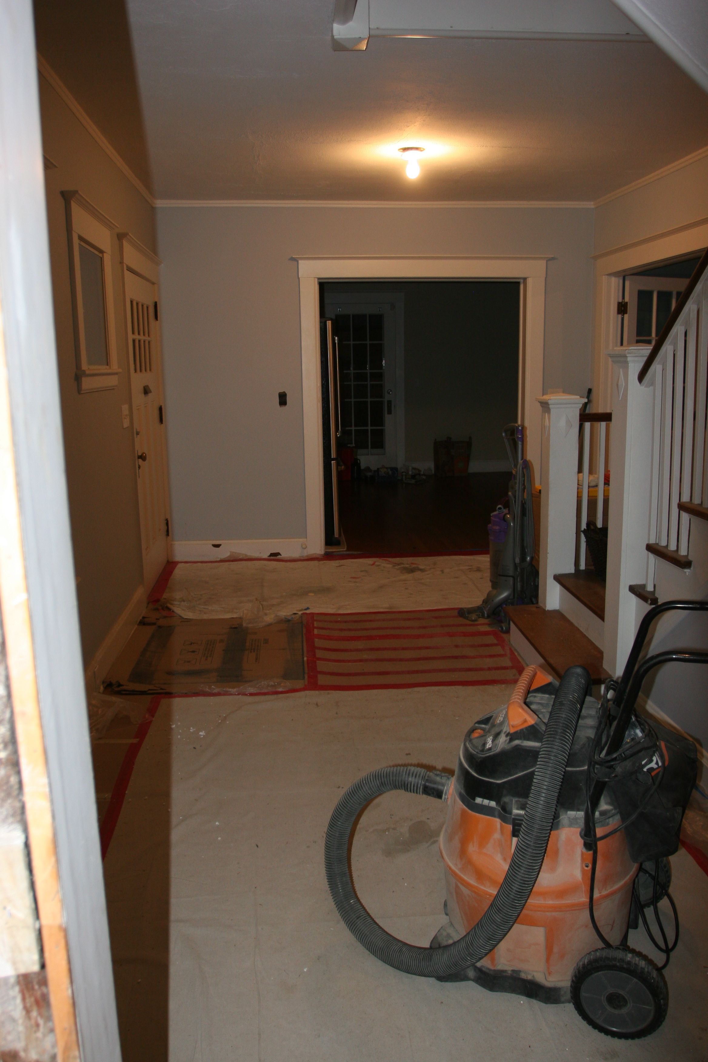 The foyer, empty but for a few mostly empty boxes, the shop-vac and some cardboard.