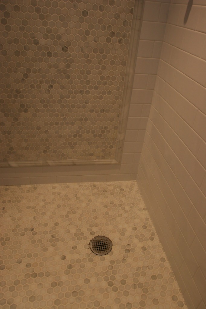 Grout DOES change everything! That little bit that's missing is on purpose - that shower drain is only temporary.