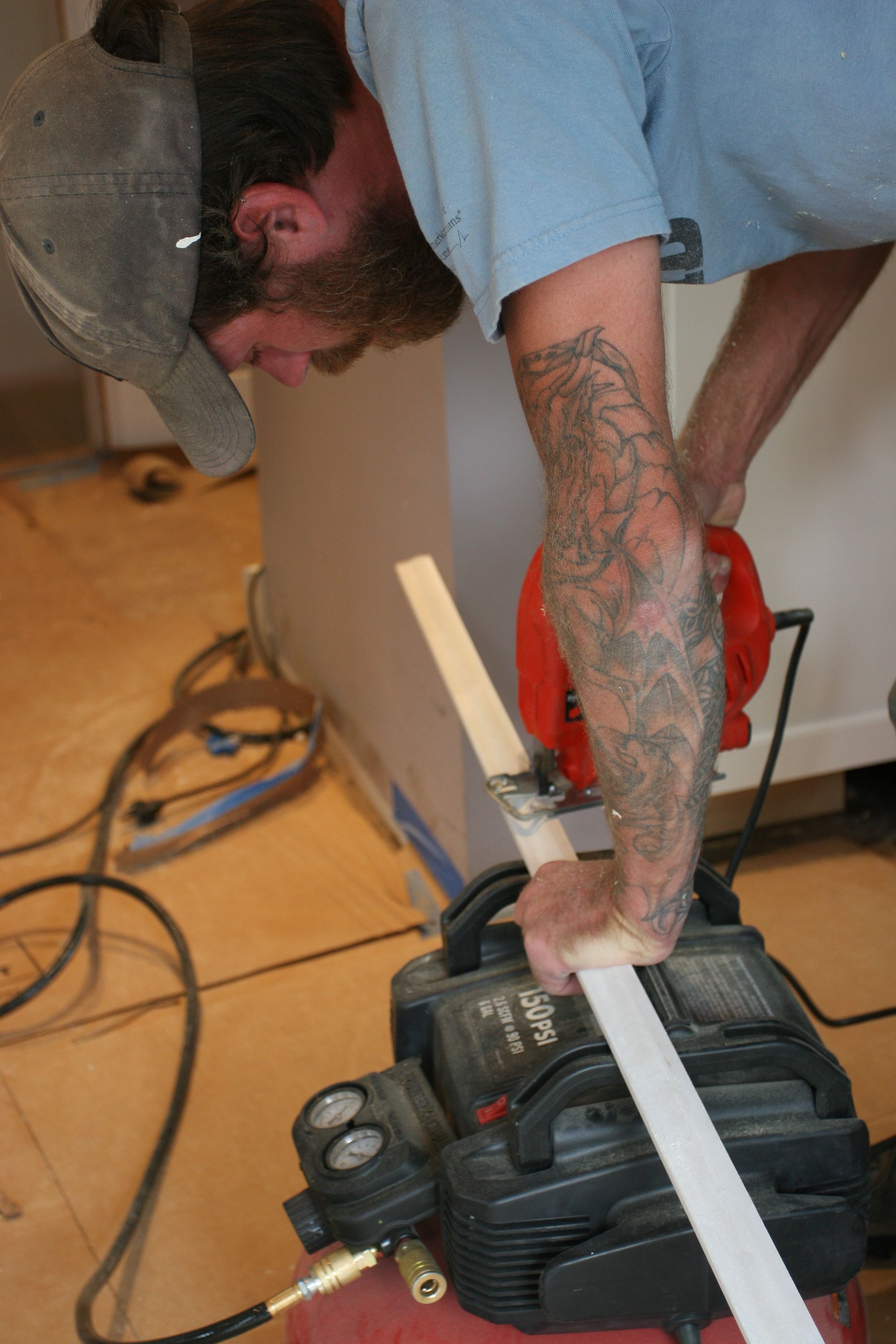 Eric jigsawing some baseboard trim to allow for the powder room water supply.