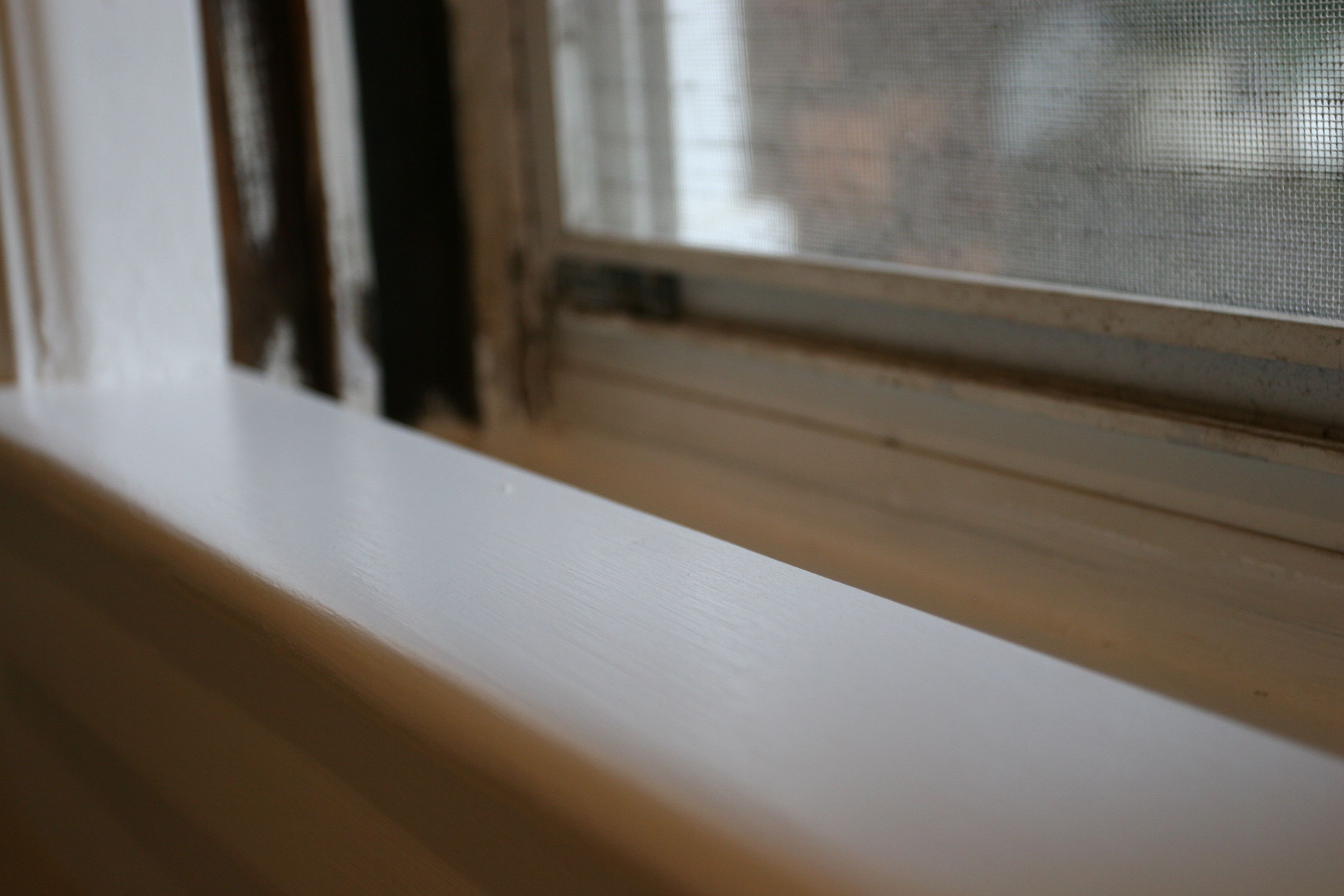 Windowsill, painted. The window was painted, scraped, sanded and refurbished. Looks like old/new.