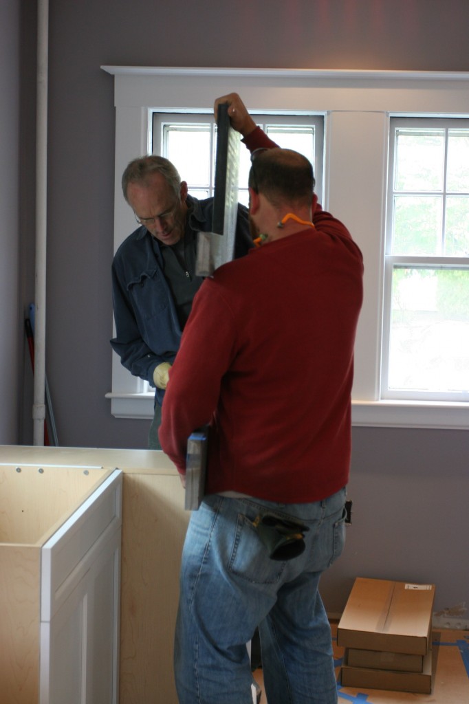 Tom and Greg hoisting the stone onto the cabinets.