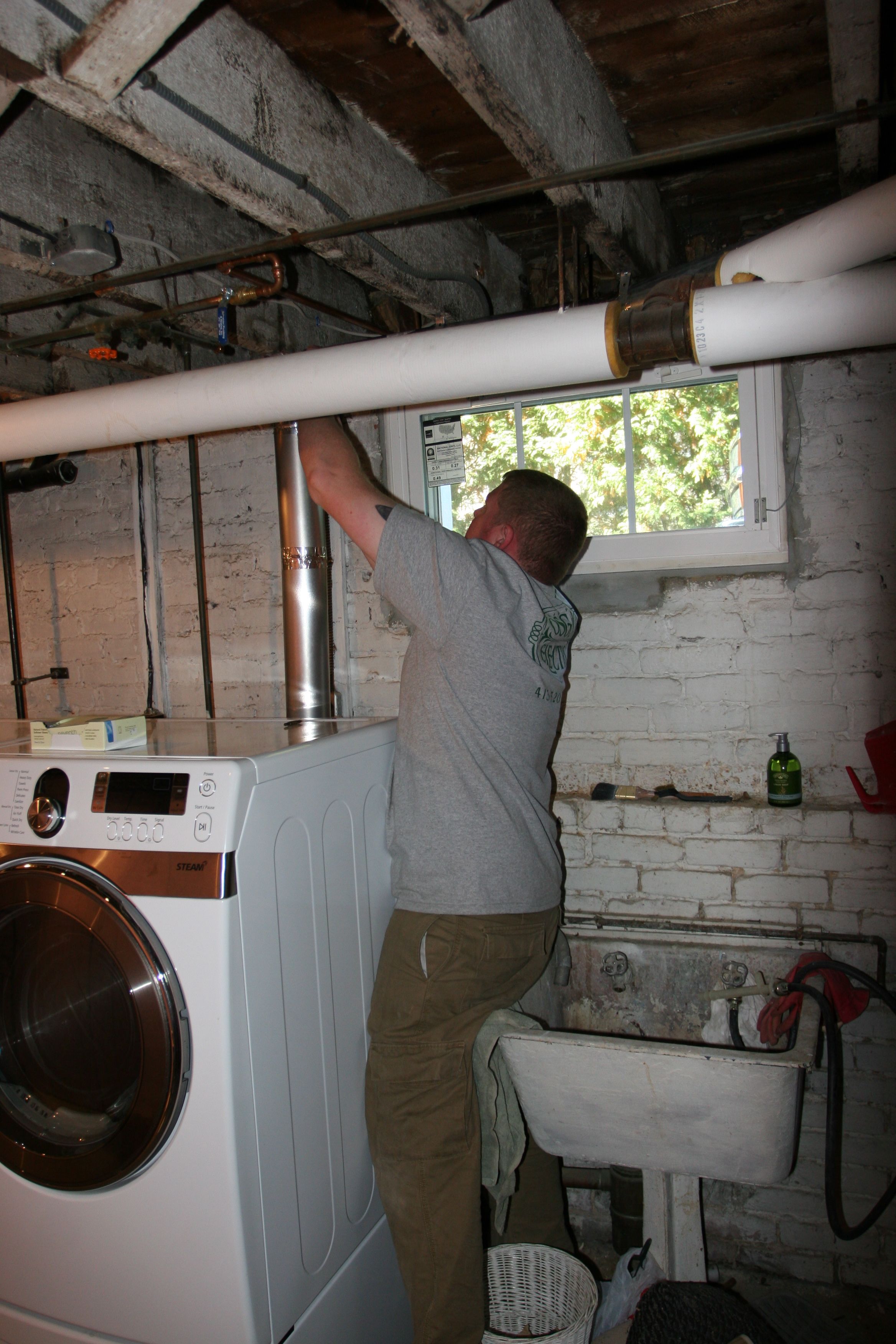 Brad fixing up our dryer vent. We have clean clothes again!
