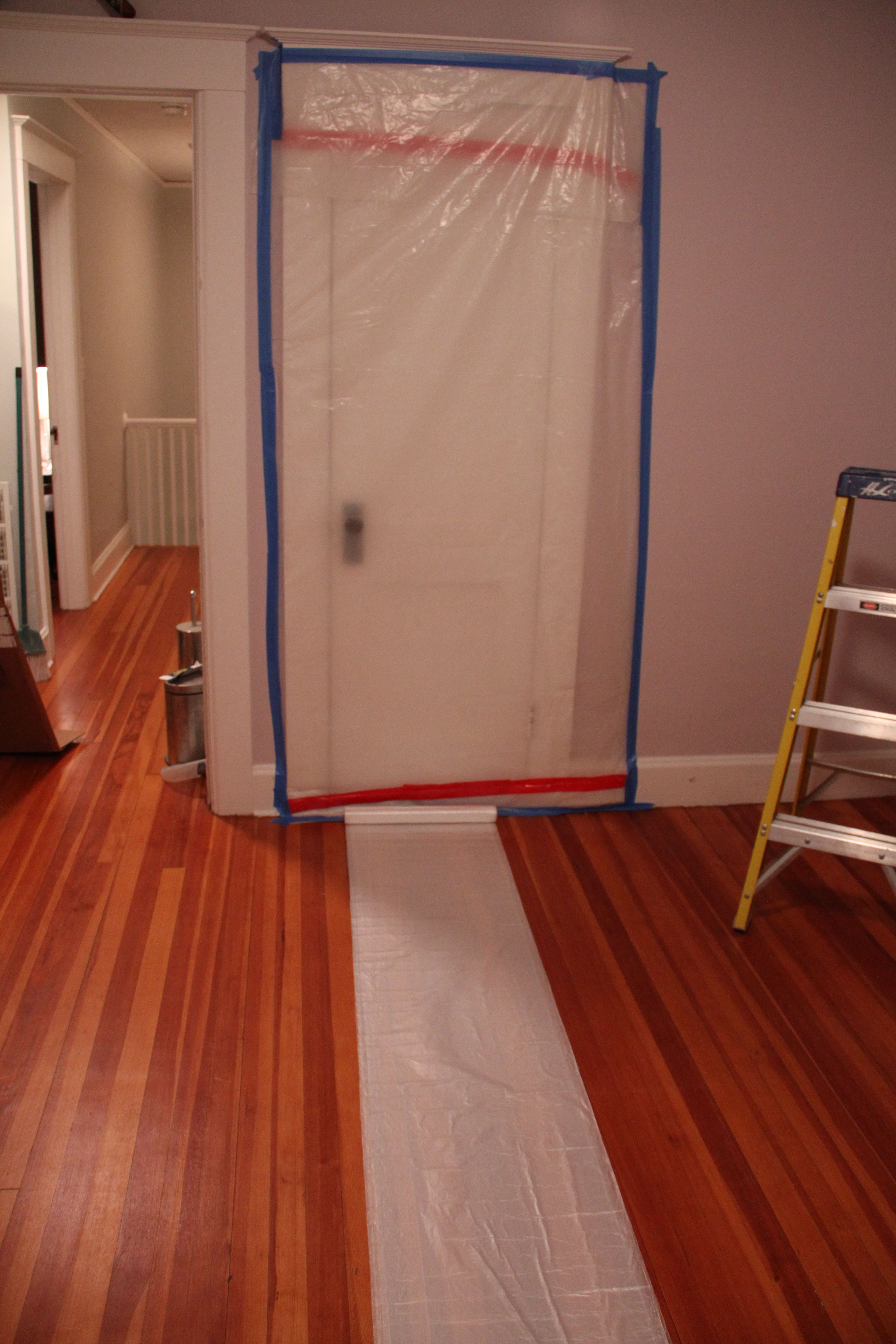 Step one: plastic. Lightweight painters' plastic should cover the floor. The room is small, so the 10' width meant we just had to cut it to length.
