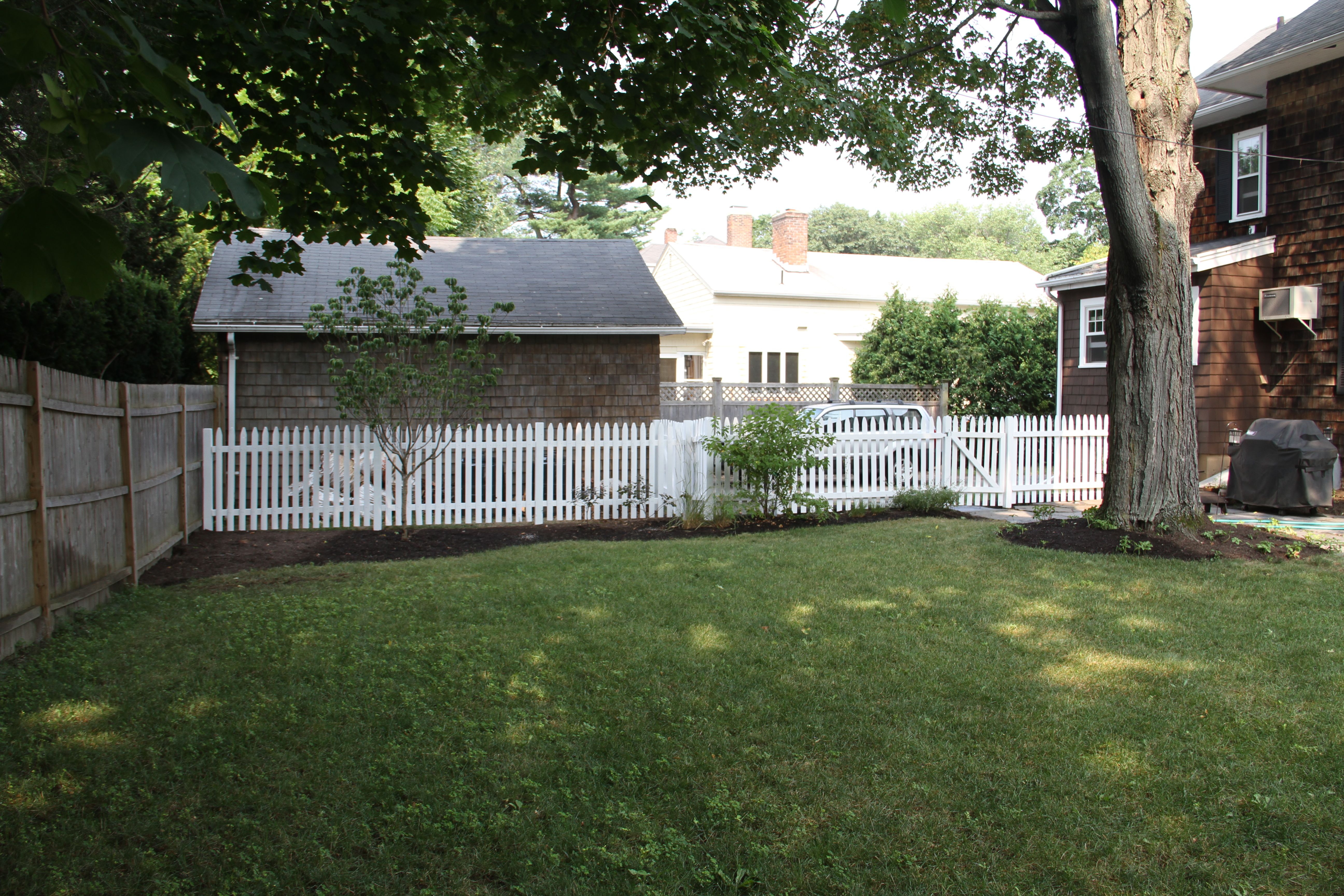 The white fencing makes the yard seem so charming and clean. Not that we don't appreciate silvery wood - we just think that the white fits in with the house better.