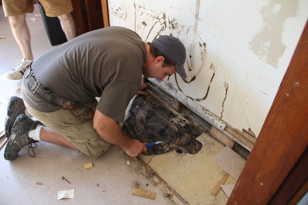 Dave sizing up the flooring. There was the hope of salvaging the hardwoods underneath all those glued down tiles.