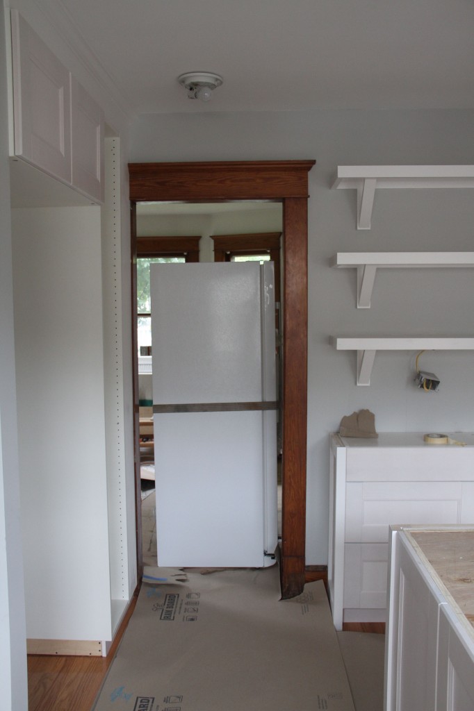 The refrigerator. Sigh. Heavy. Delayed. Handles removed. Floors protected. Finally, finally in place.