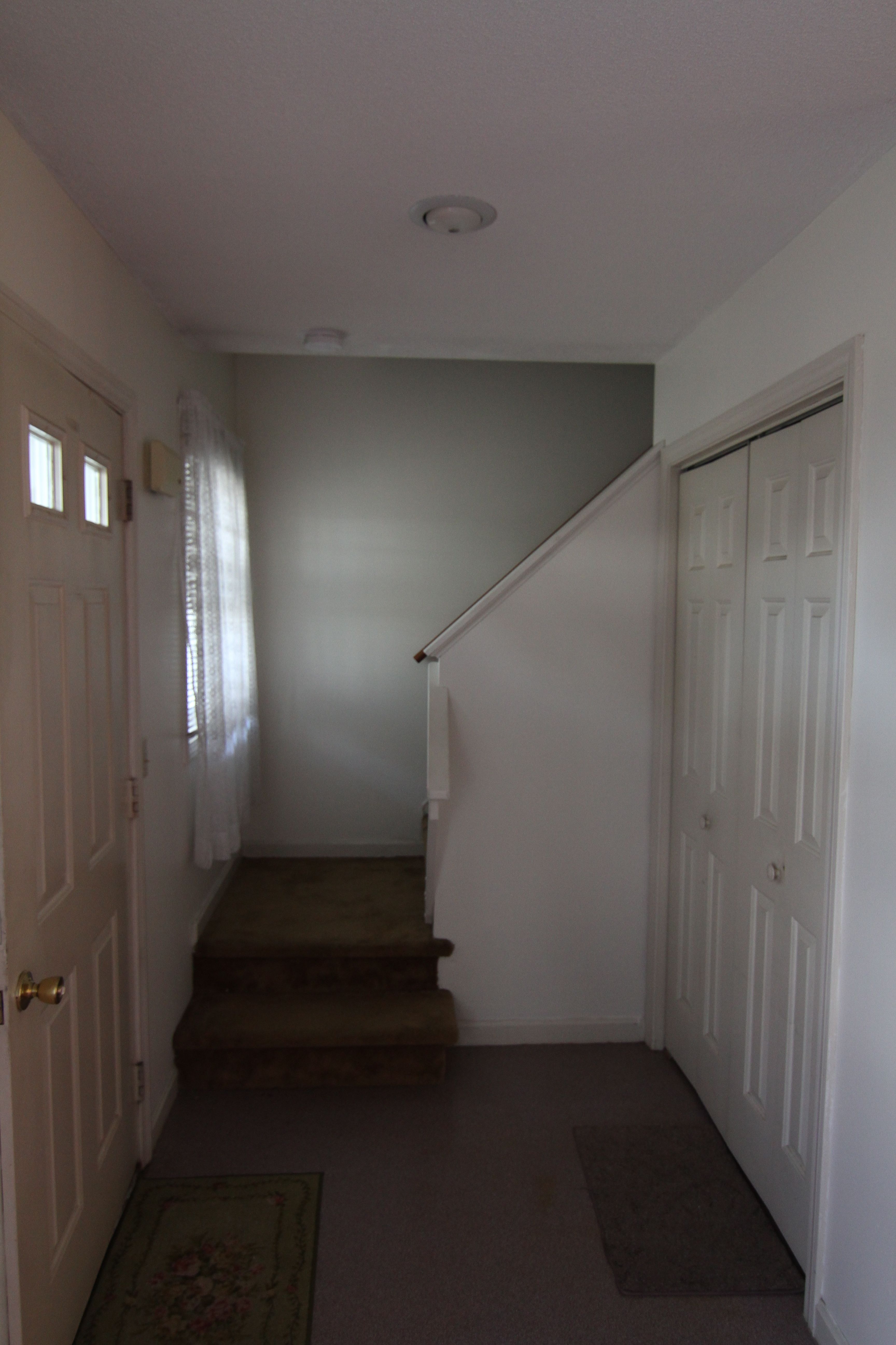 The entryway BEFORE: grungy, carpet and linoleum, needing a bit of paint and love.