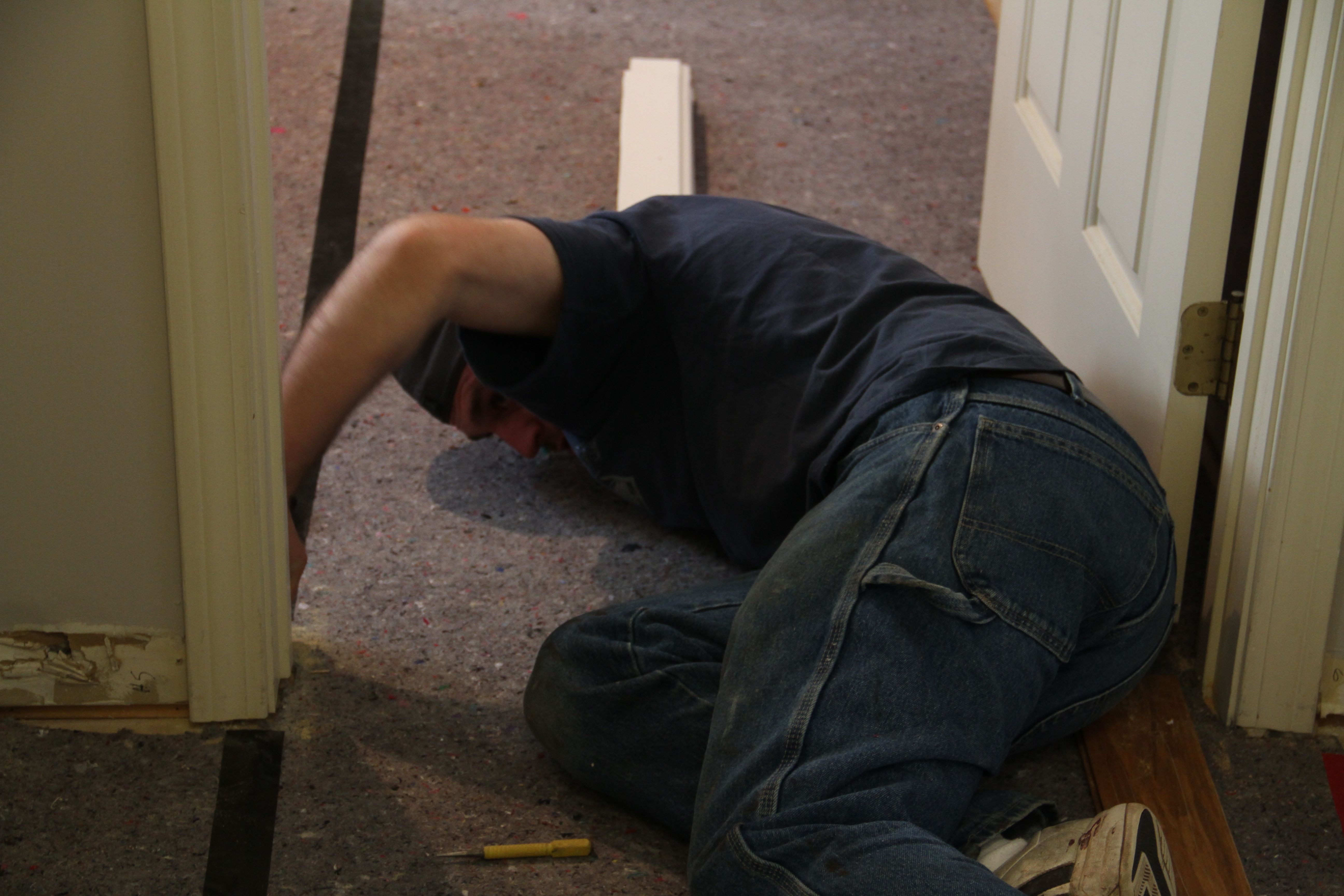 Jonas went ahead of Dave and Brian to remove the part of the door jamb that was previously buried in the carpeting.