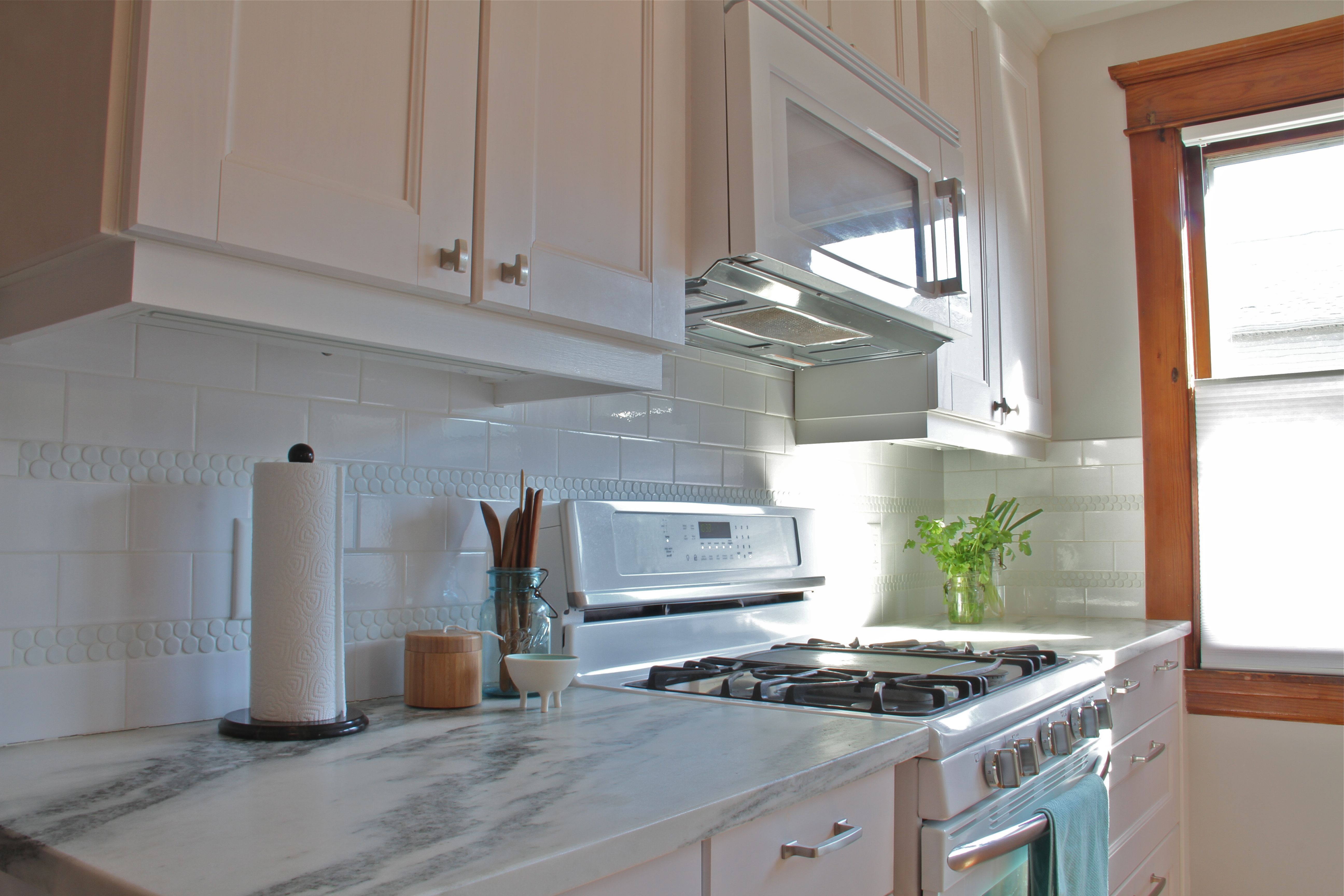 AFTER: Now the light floods the space, and the prep areas are nearly 3' wide. Plus, the built-in microwave hood is an efficient solution for small kitchens.