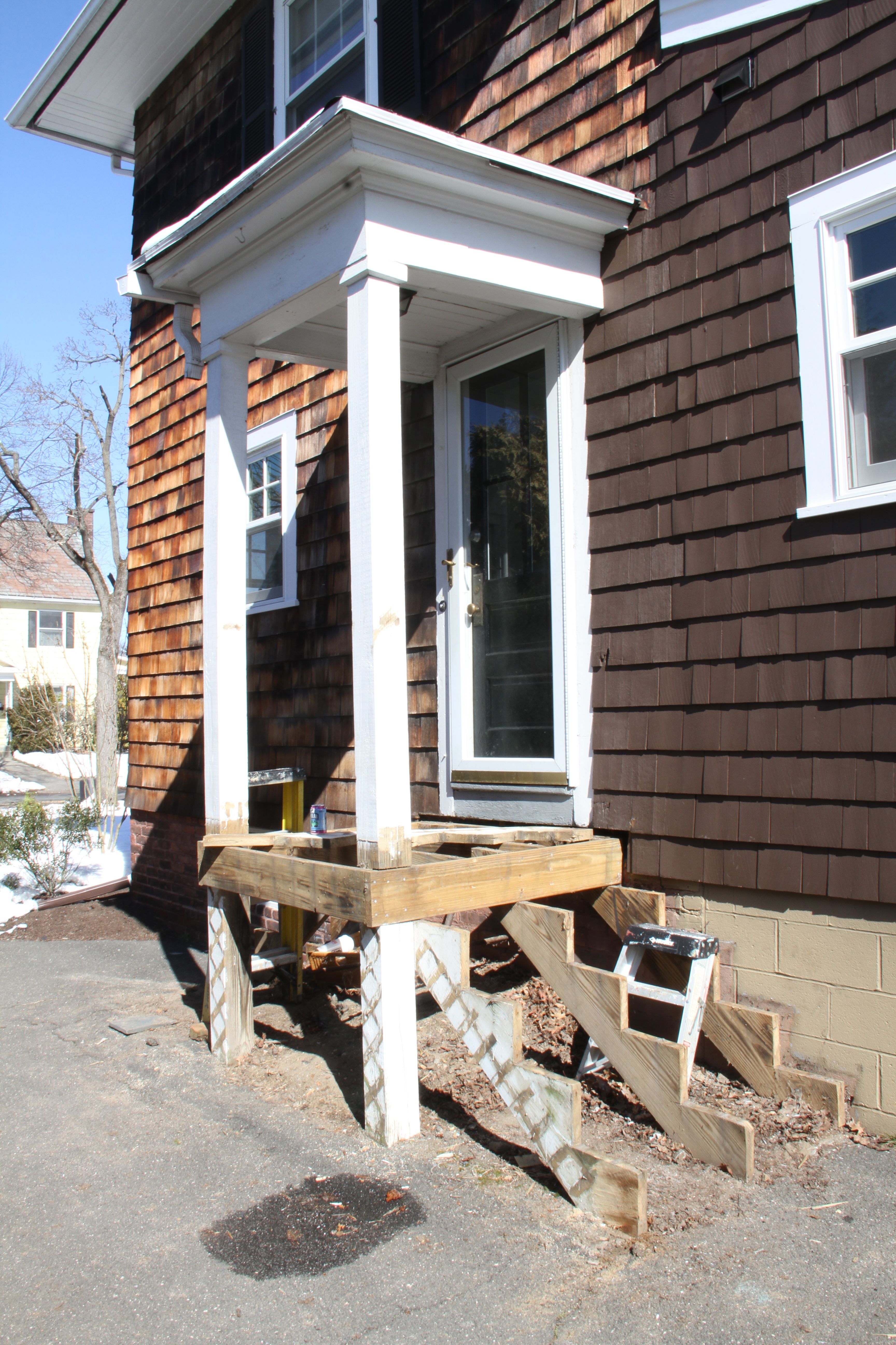 DURING: Our plan is to redo the railings to match the other side of the house, use cedar to wrap all the pressure treated (i.e., ugly) lumber, and to replace the storm door that pretty much failed after our kitchen renovation.