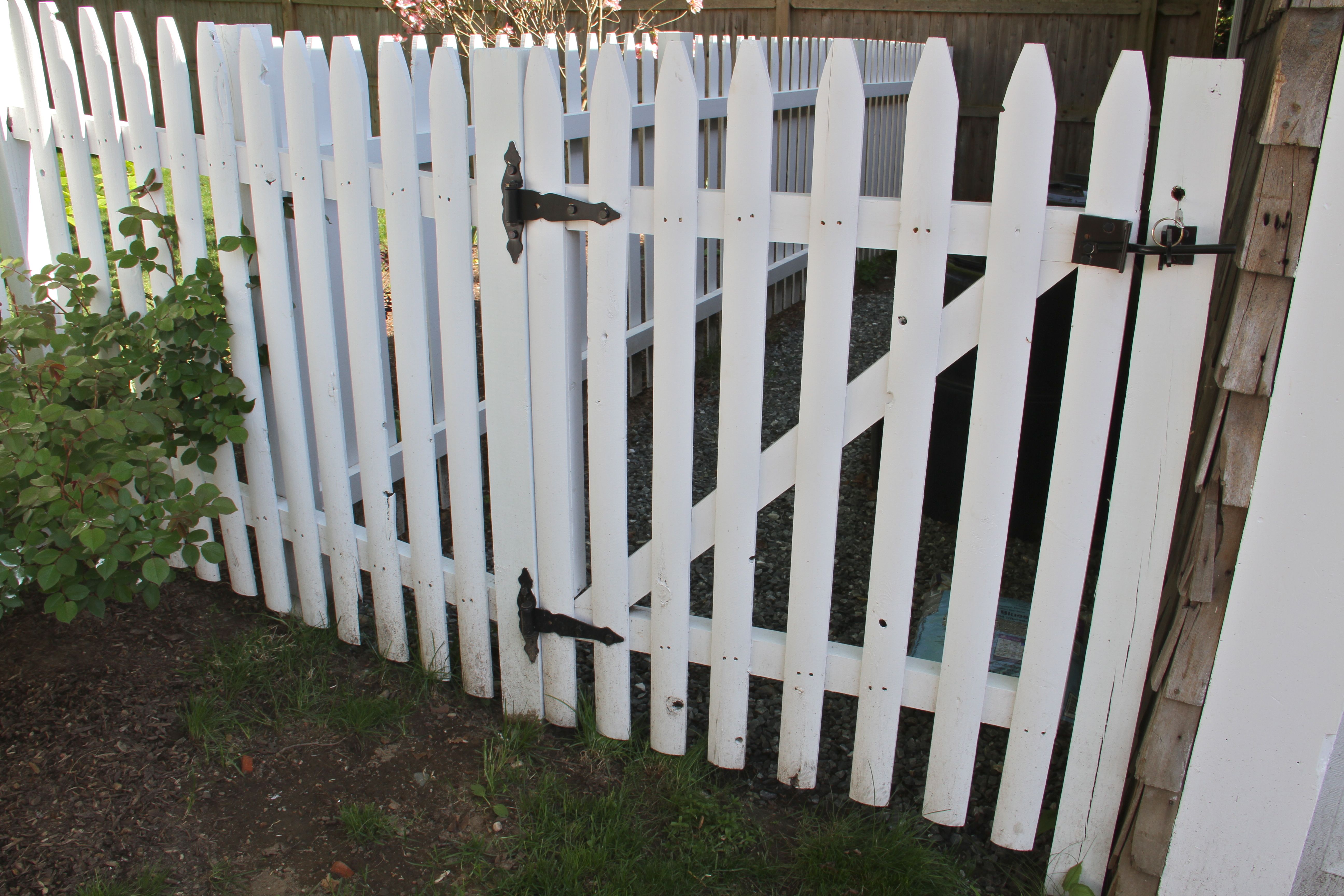 AFTER: Plain white on the fencing gives a crisp tie-in to the white trim throughout the entire house. Plus, if you have a picket fence, and you live in New England, why not make it a classic 'white picket fence'?