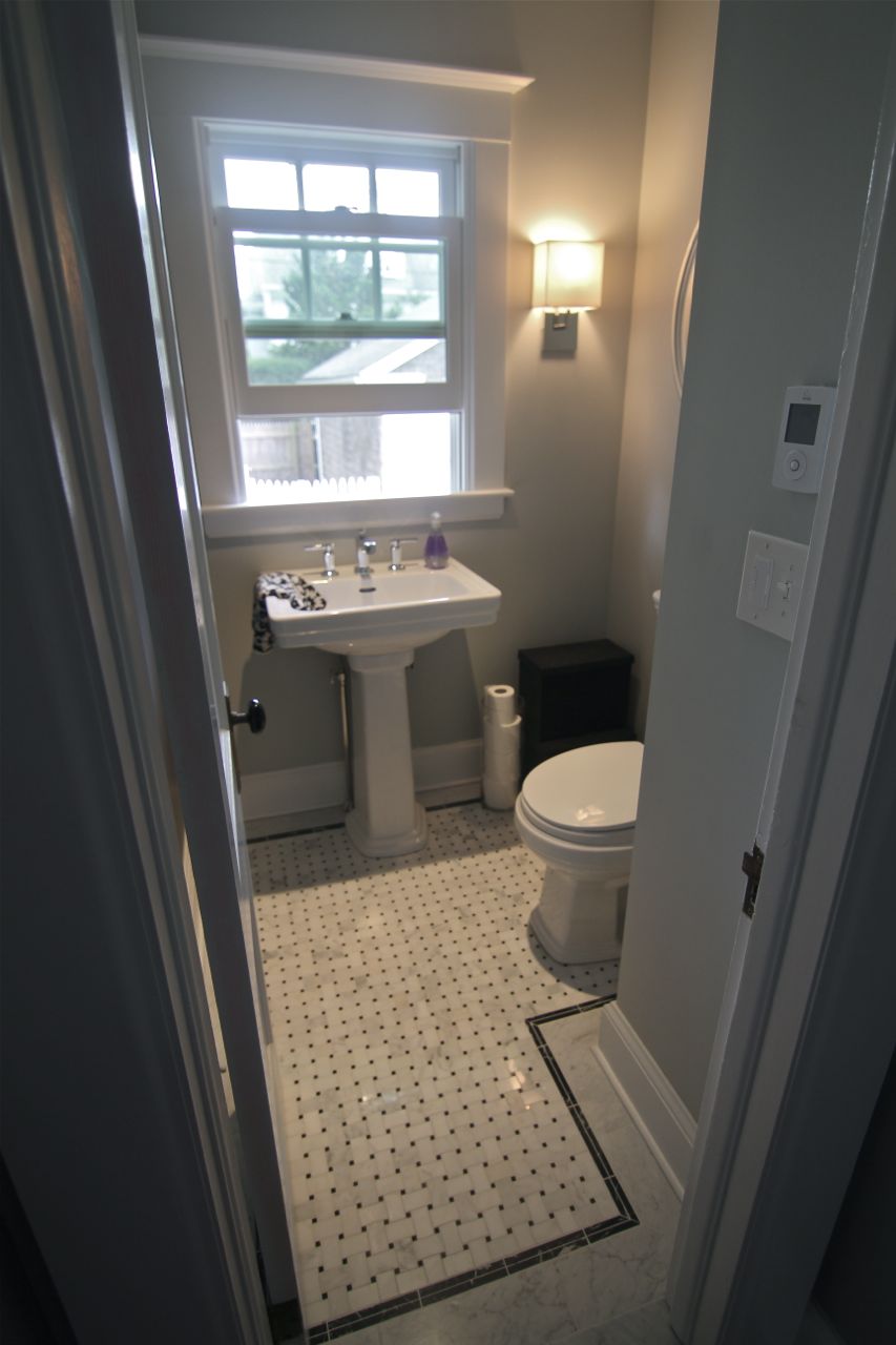 Powder room on the main level features a new window, water-saving toilet, marble floors and radiant electric floor heat.