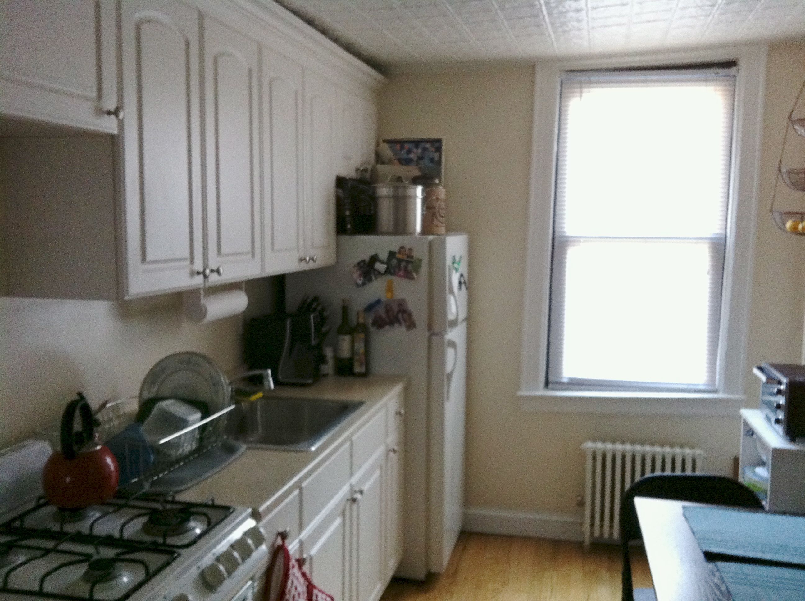 BEFORE: The kitchen, while sporting new cabinets, have decidedly shorter ceilings. And that stove was broken, and has since been replaced with our old one from upstairs.