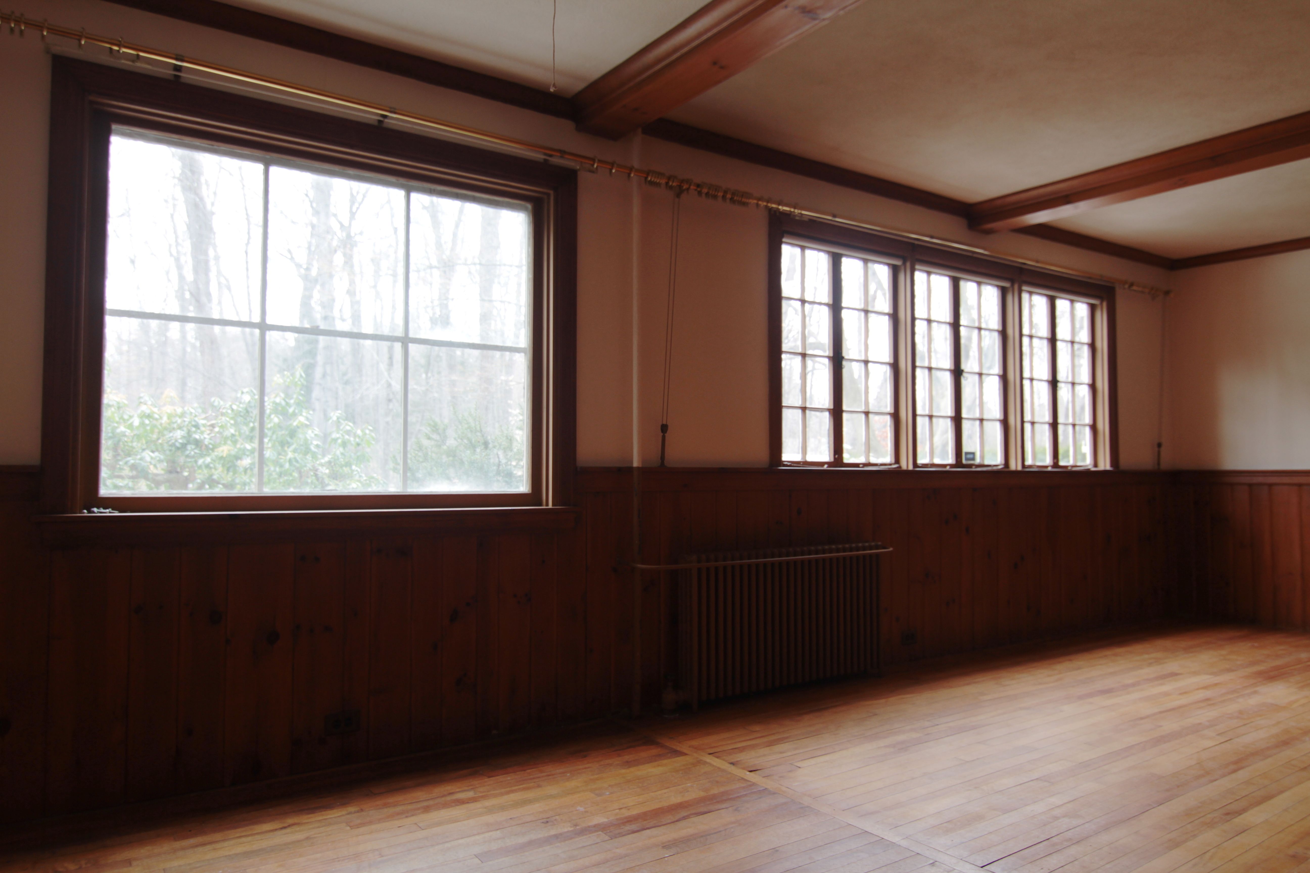 BEFORE: Views onto a wooded park, and lots of character in real wood paneling and faux beams. So English, right?